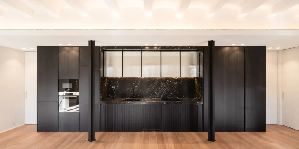 A Light-Filled Living Space Anchored by a Dark Stone Kitchen